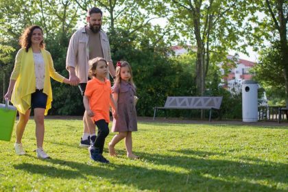 A joyful family with children strolling in a sunny Portuguese park.